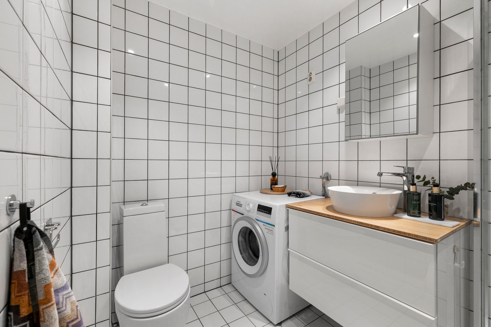 Lyst og funksjonelt bad med flislagt gulv og vegger, elektriske varmekabler samt malt himling med downlights. Galleribilde