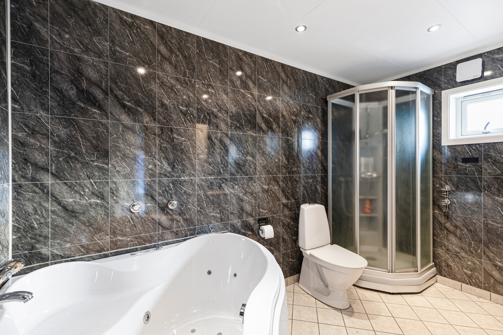 Badet har flislagt gulvoverflate og våtromsplater på vegger. Galleribilde