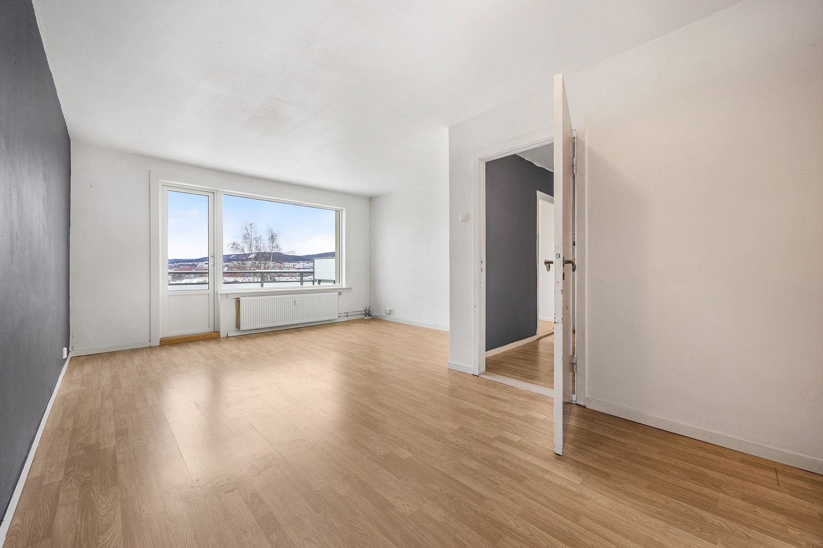 Stuen er romslig med en takhøyde på 2,45 meter, laminat på gulv og malte veggflater. Galleribilde