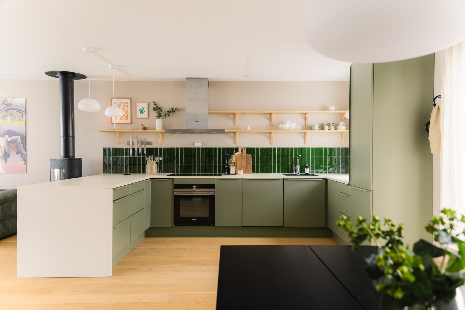 Delikat HTH-kjøkken i åpen løsning mot stuen, med slette fronter og tidløst design. Galleribilde