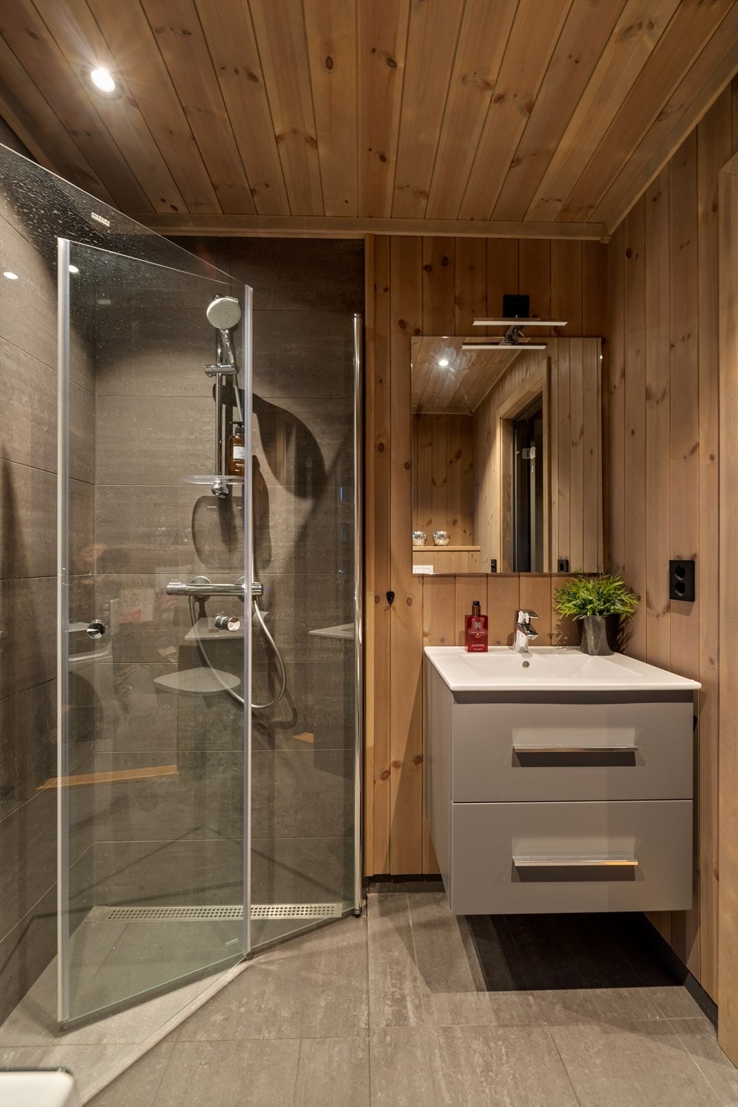 Badet er innredet baderoms innredning, dusjhjørne og vegghengt toalett Galleribilde