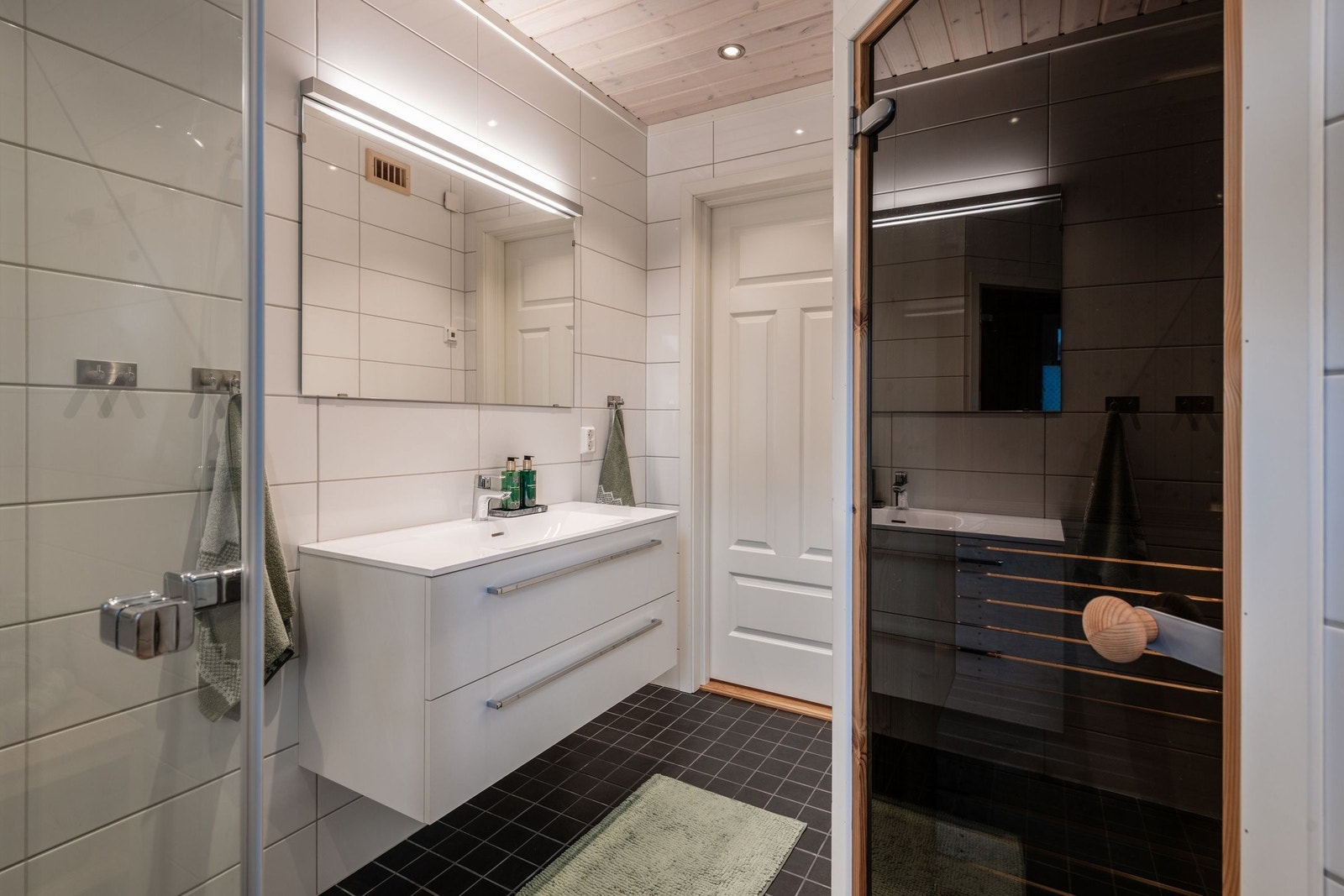 Leiligheten har to flislagte bad, begge med toalett, servant med skuffer, dusjhjørne og varmekabler. Galleribilde