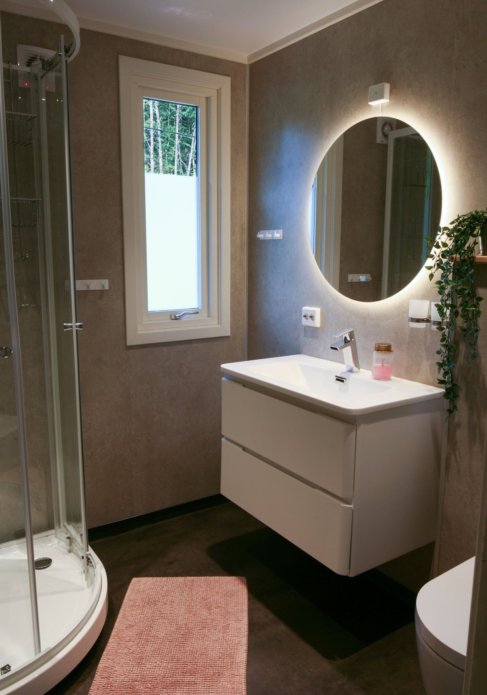 Badet har et moderne uttrykk med mørke flater og hvite detaljer, og ble totalrenovert i 2023. Galleribilde