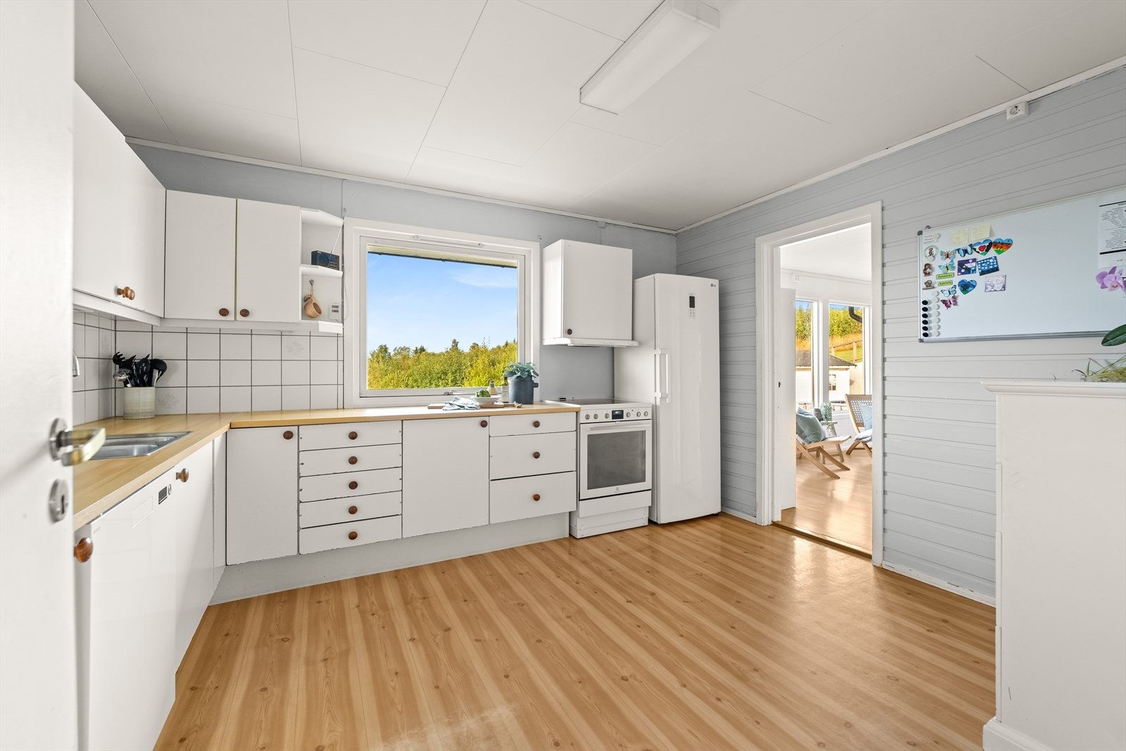 Lys kjøkkeninnredning med god skap- og benkeplass. Rommet gir fin plass til kjøkkenbord. Galleribilde