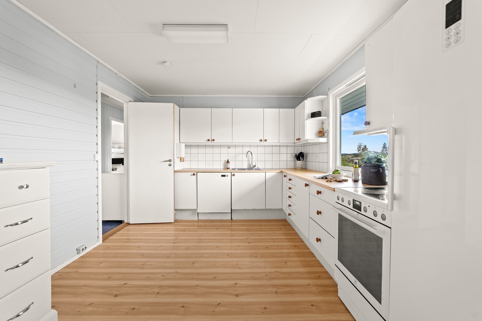 Kjøkkenet er innredet med glatte fronter og benkeplaten av laminat. Det er kjøkkenventilator med avtrekk ut. Galleribilde