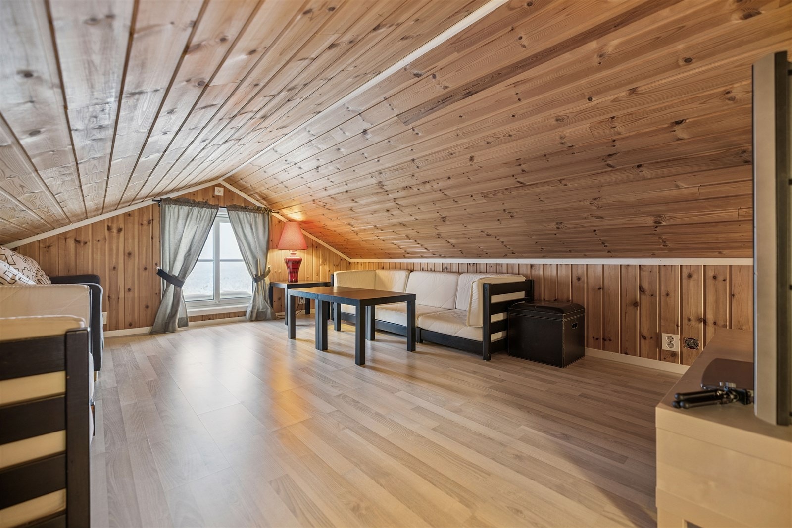 En lys og åpen hems med panelkledde vegger og tak som gir en lun atmosfære. Galleribilde