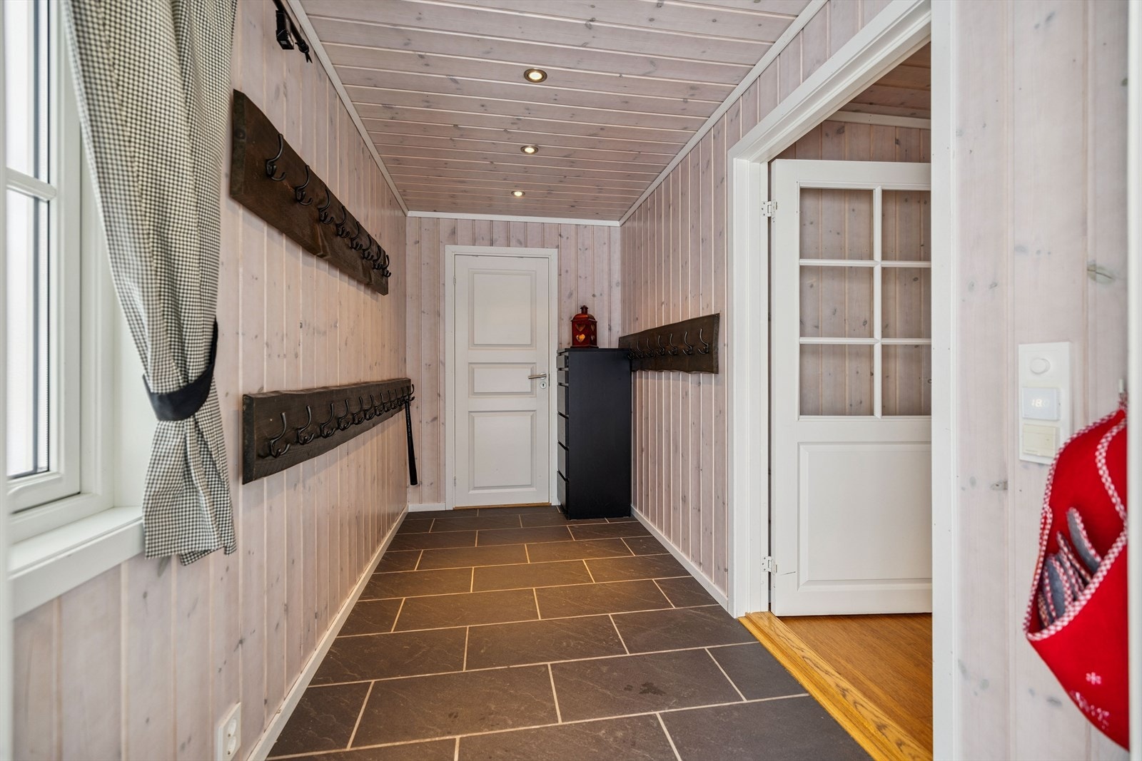 Velkommen inn i en romslig entré med skiferfliser på gulv og rikelig med plass til yttertøy. Galleribilde
