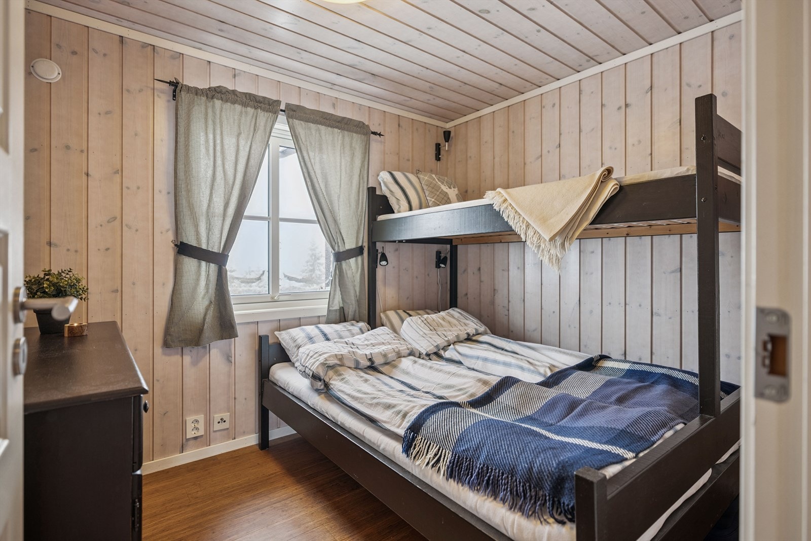 Et av soverommene i første etasje med plass til både dobbeltseng og oppbevaringsmøbler. Galleribilde