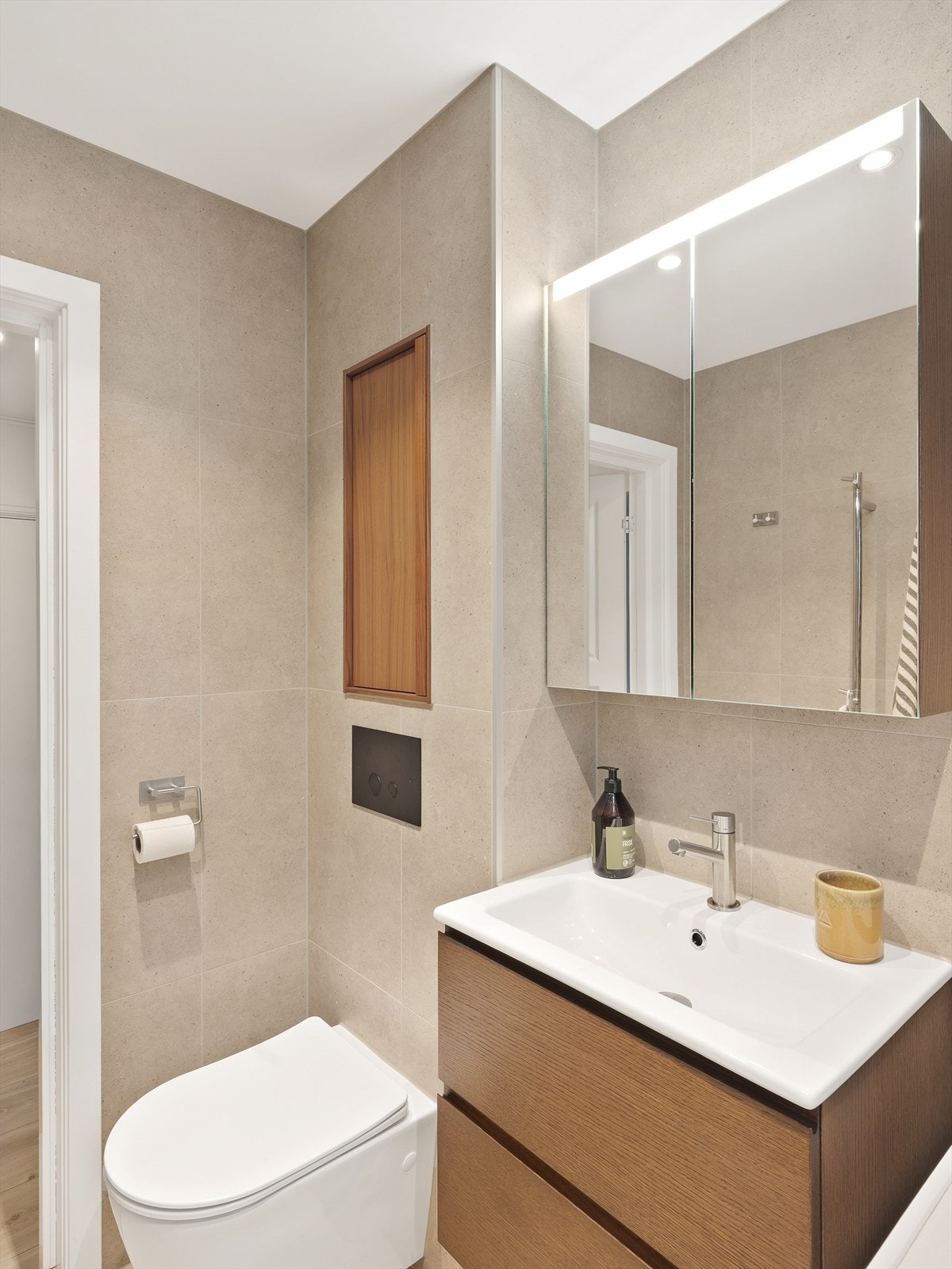 Baderomsinnredning med servant og speilskap gir praktisk oppbevaringsplass. Galleribilde