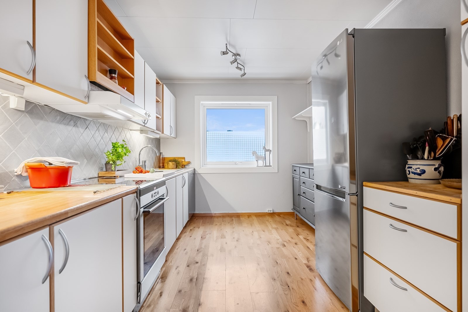 Praktisk kjøkken med hvitevarer, godt med benkeplass og naturlig lys. Galleribilde