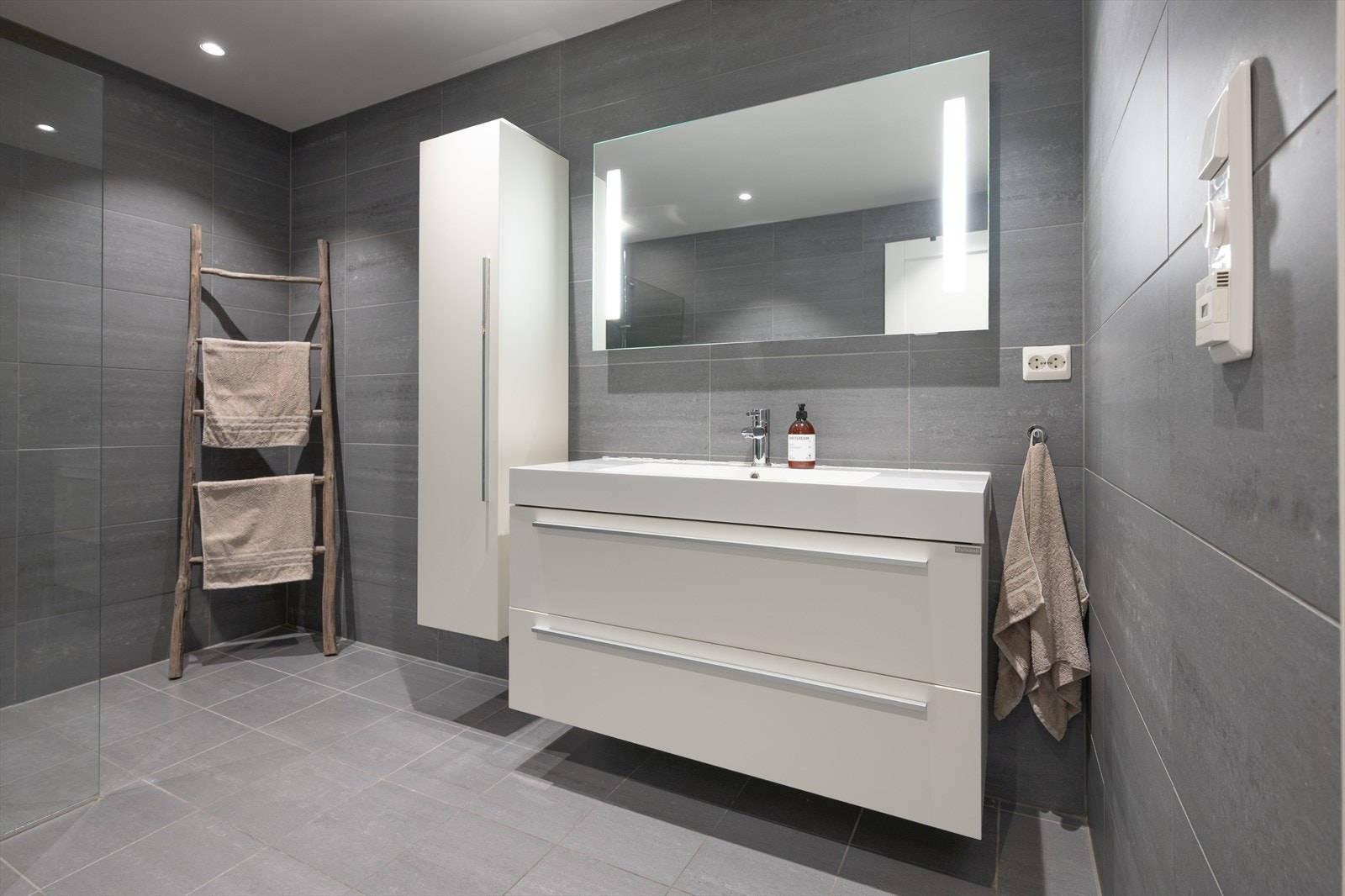 Stilren innredning med høyskap, skuffer og heldekkende vask Galleribilde