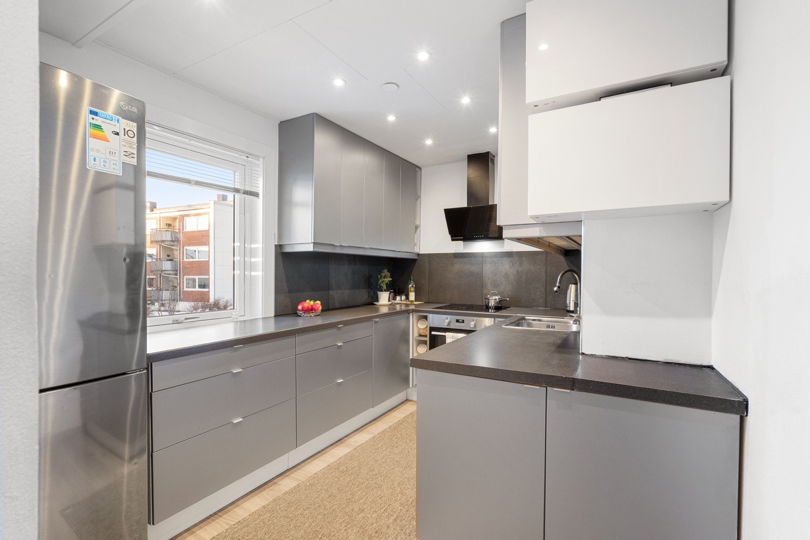 Kjøkkenet har en moderne og stilren innredning med glatte fronter, mørk benkeplate og integrerte løsninger som gir et helhetlig uttrykk. Galleribilde