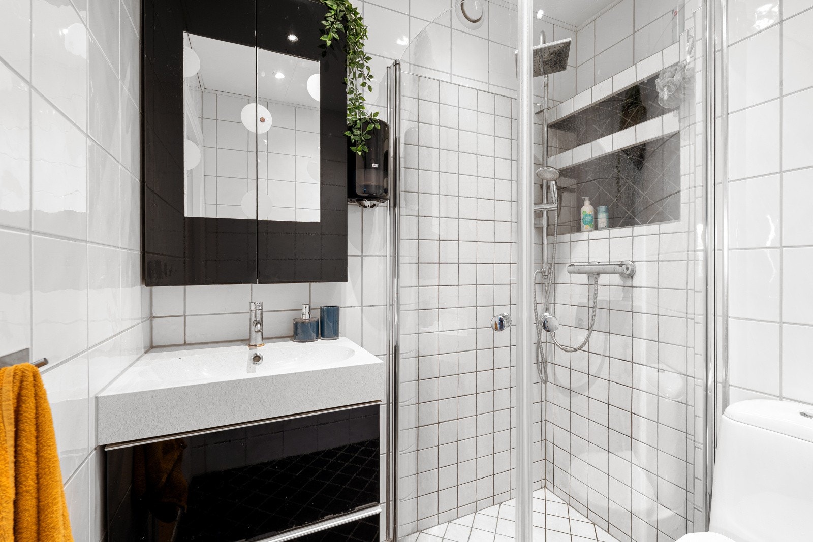 Rommet er utstyrt med dusjhjørne, gulvmontert toalett og servant i skap. Galleribilde