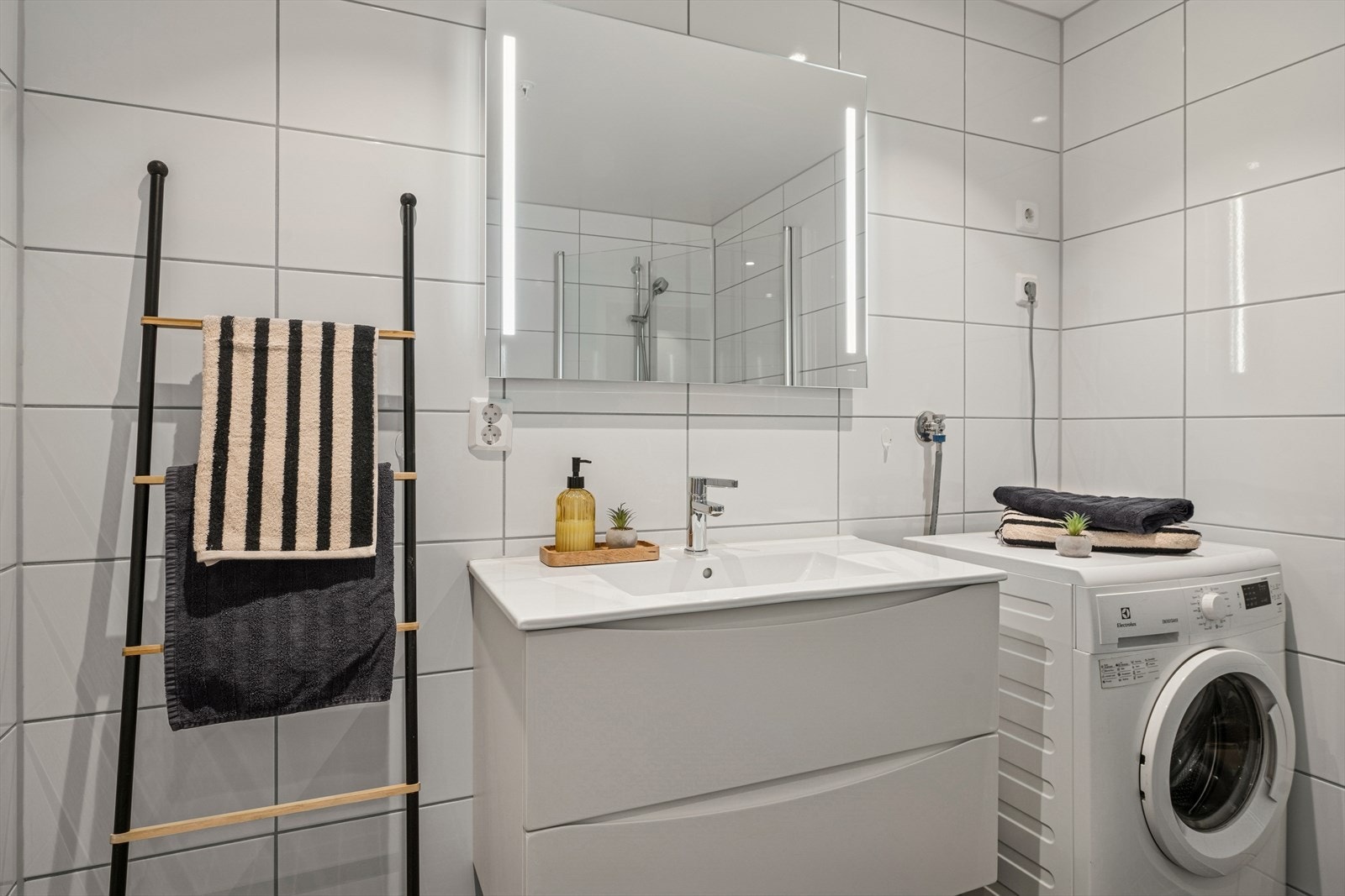 Her er det veggmontert toalett, innredning med nedfelt servant og opplegg for vaskemaskin. Galleribilde