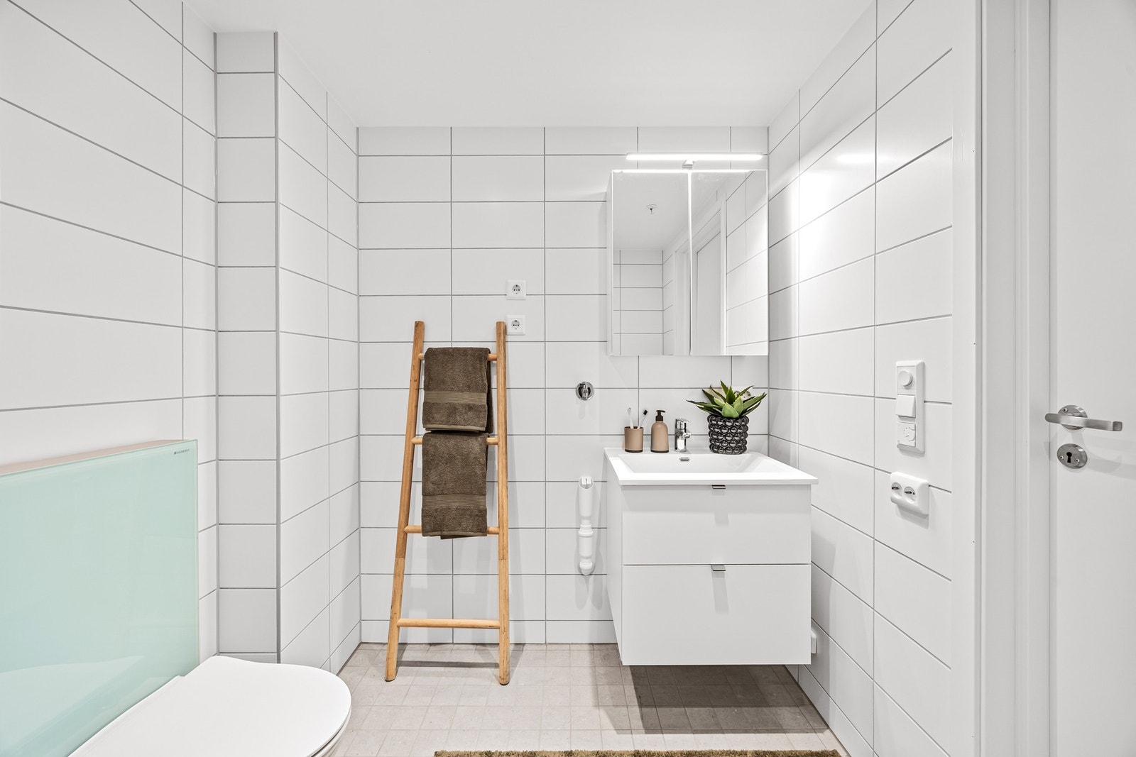 Servantinnredning med skuffer under. Vegghengt speilinnredning med hyller der toalettsaker kan legges. Galleribilde