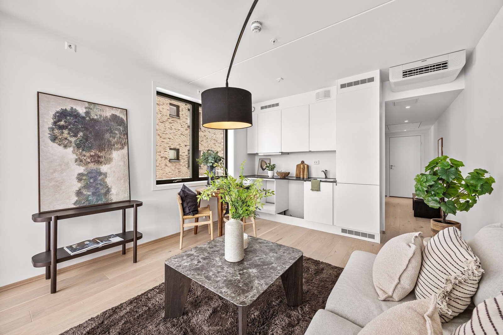 Rommet er innredet med sofa, stuebord, belysning og spisemøbler. Galleribilde