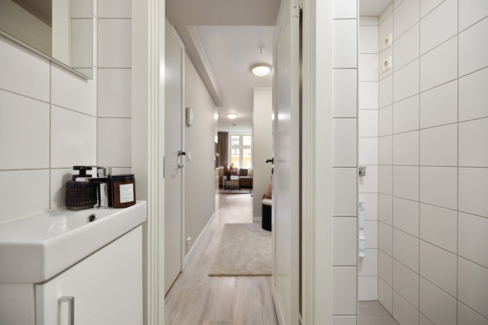 Badet er innredet med vegghengt toalett, dusjsone speil og servant med innredning. Galleribilde