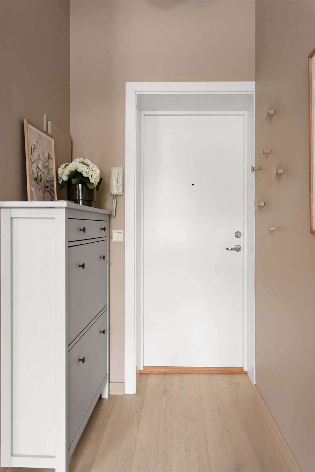 Velkommen inn! En lys og innbydende entré som gir et godt førsteinntrykk av leiligheten. Det medfølger en kjellerbod på 3 kvm for ekstra lagring. Galleribilde