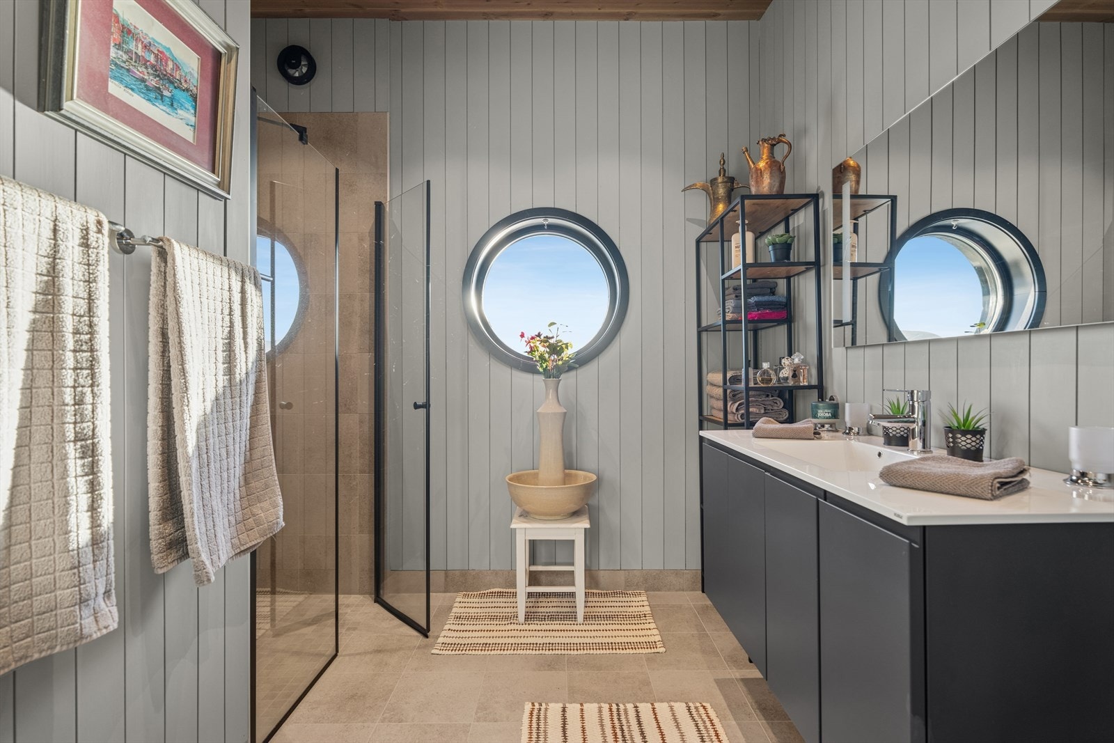 Rommet har flislagt gulv med behagelig gulvvarme, som sikrer en komfortabel temperatur året rundt. I dusjsonen er også veggene flislagt, mens de øvrige veggflatene har malt panel som skaper et lunt og harmonisk uttrykk. Galleribilde