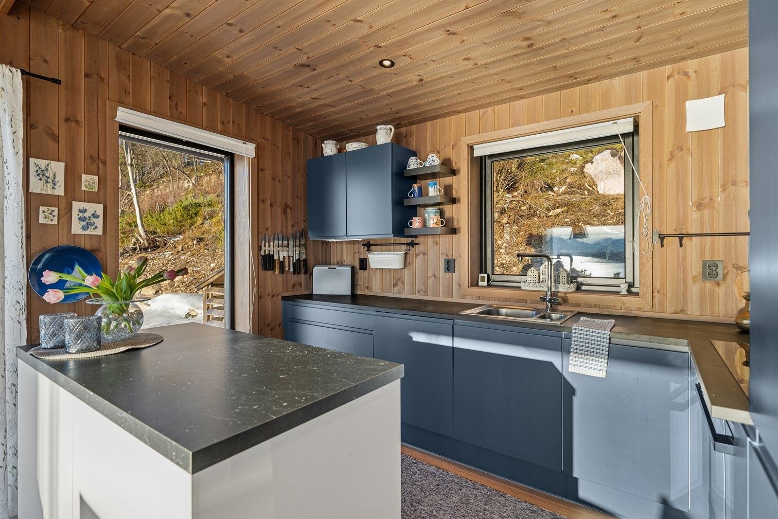 Kjøkkenet fra byggeår fremstår moderne og funksjonelt, og har en åpen løsning som glir naturlig over i både stue og spisestue. Innfelte spotlights i taket sørger for god og jevn belysning. Galleribilde