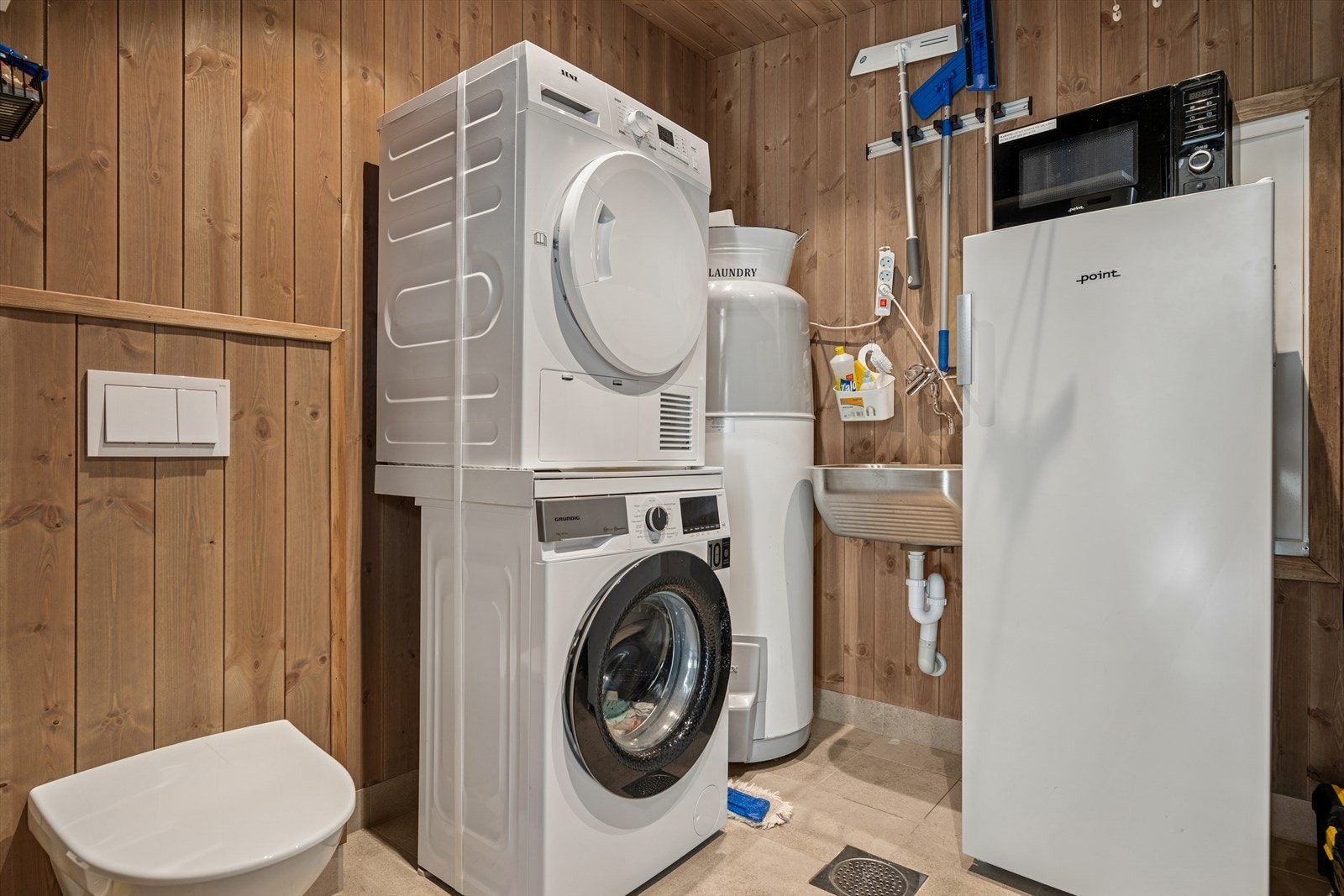 Rommet er byggemeldt som bod/teknisk rom/WC, men brukes i dag som et vaskerom. Flislagt gulv med gulvvarme, vegghengt toalett, skylleskål og opplegg for vaskemaskin/tørketrommel. Varmtvannsbereder og fordelerskap for rør-i-rør. Se pkt. ferdigattest. Galleribilde