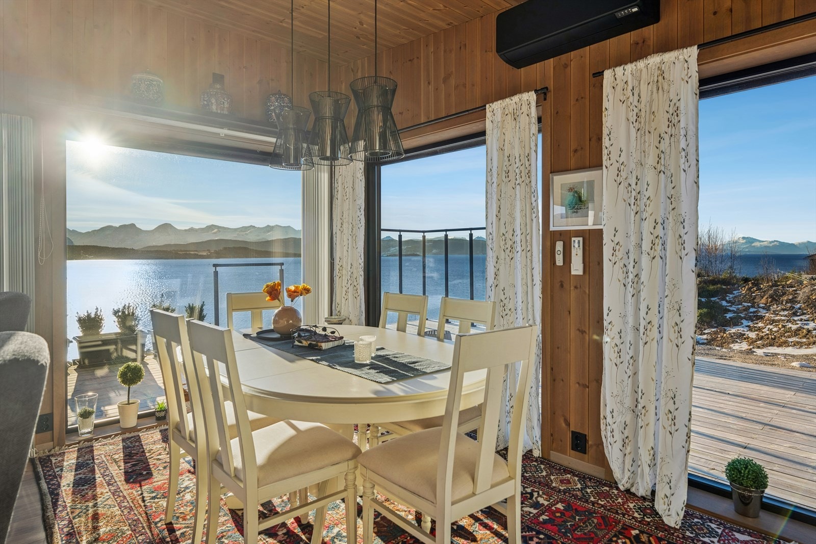 Rommet har god plass til både en romslig sofagruppe og et stort spisebord, noe som gjør det ideelt både for hyggelige familiestunder og sosiale sammenkomster. Galleribilde