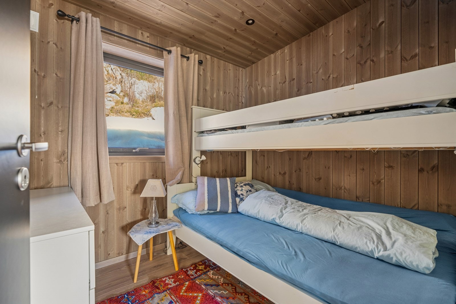 Det tredje soverommet er smart innredet med en praktisk etasjeseng, noe som utnytter gulvarealet svært godt. Dette rommet passer perfekt til barn, ungdom eller som ekstra gjesterom. Galleribilde