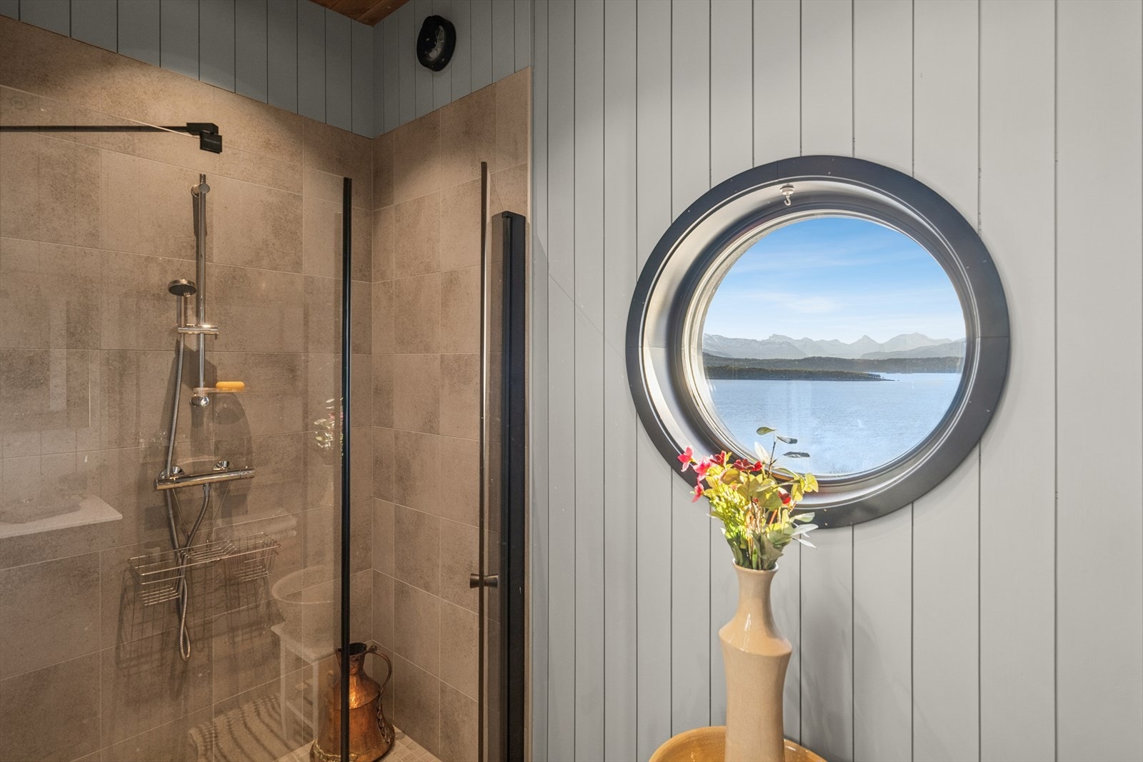 Baderommet har et lekkert rundt vindu som tilfører rommet både karakter og naturlig lys. Her får du et unikt blikkfang som samtidig åpner for en nydelig utsikt mot fjord og fjell. Galleribilde