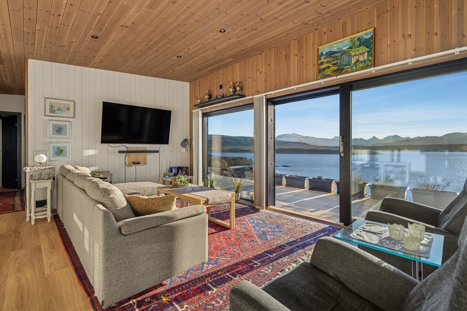 Videre inn i boligen kommer du til fritidsboligens hjerte - den åpne løsningen med stue, spisestue og kjøkken samlet i ett stort og innbydende oppholdsrom. Galleribilde