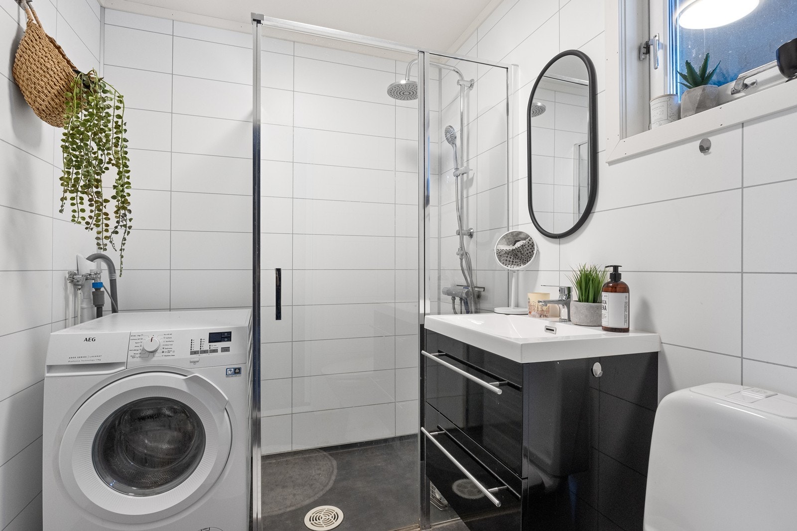 Badet er modernisert i 2021 med baderomsplater på vegger og vinylbelegg på gulv. Dusjen har en fast glassvegg og glassdør, mens rommet ventileres naturlig. Galleribilde