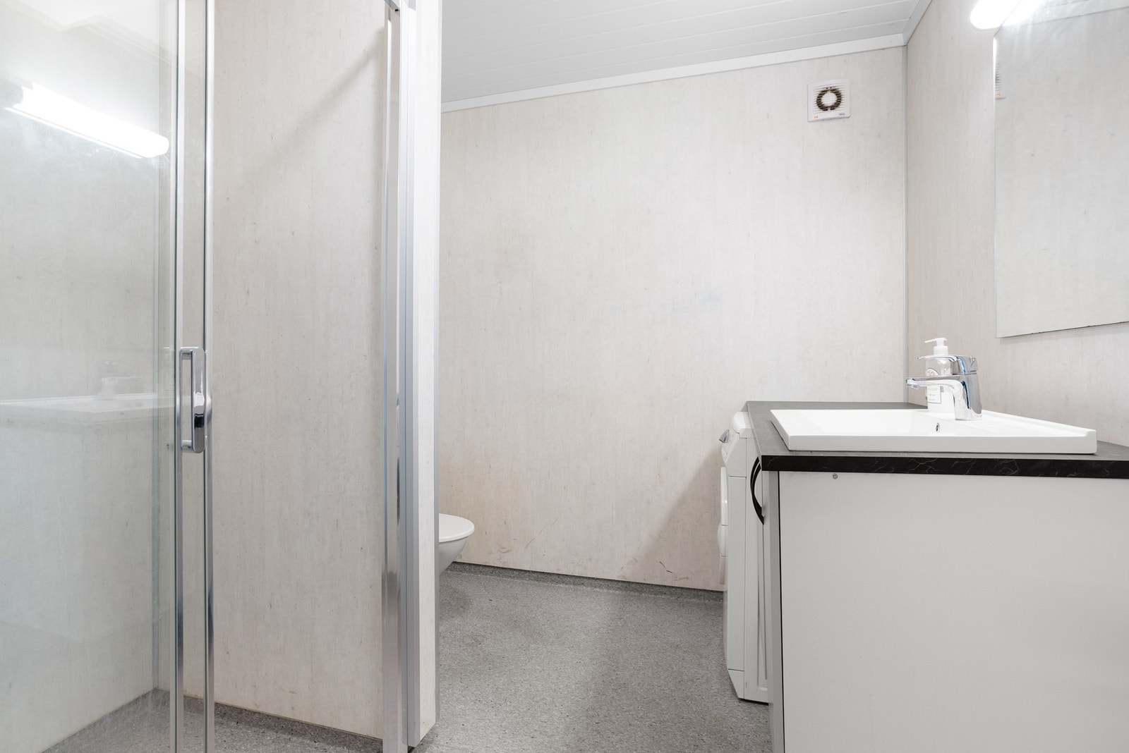 Bad med gulvmontert toalett og dusj Galleribilde