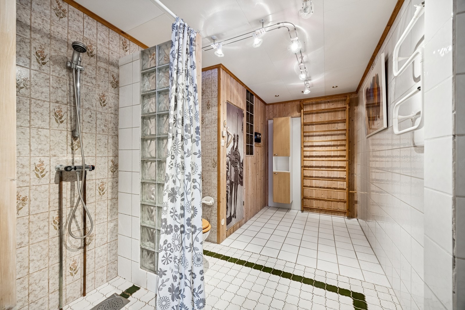 Romslig flislagt bad med dusj og toalett Galleribilde