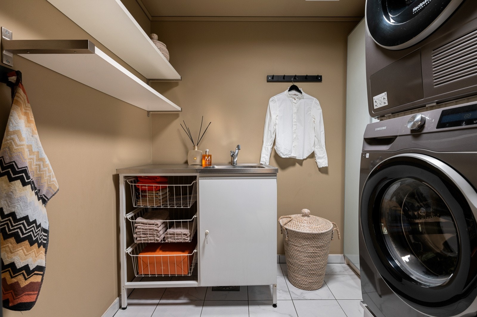 Vaskerom med uttak for vaskemaskin. Innredning med skylekum, skuffer og skap. Gulvvarme Galleribilde