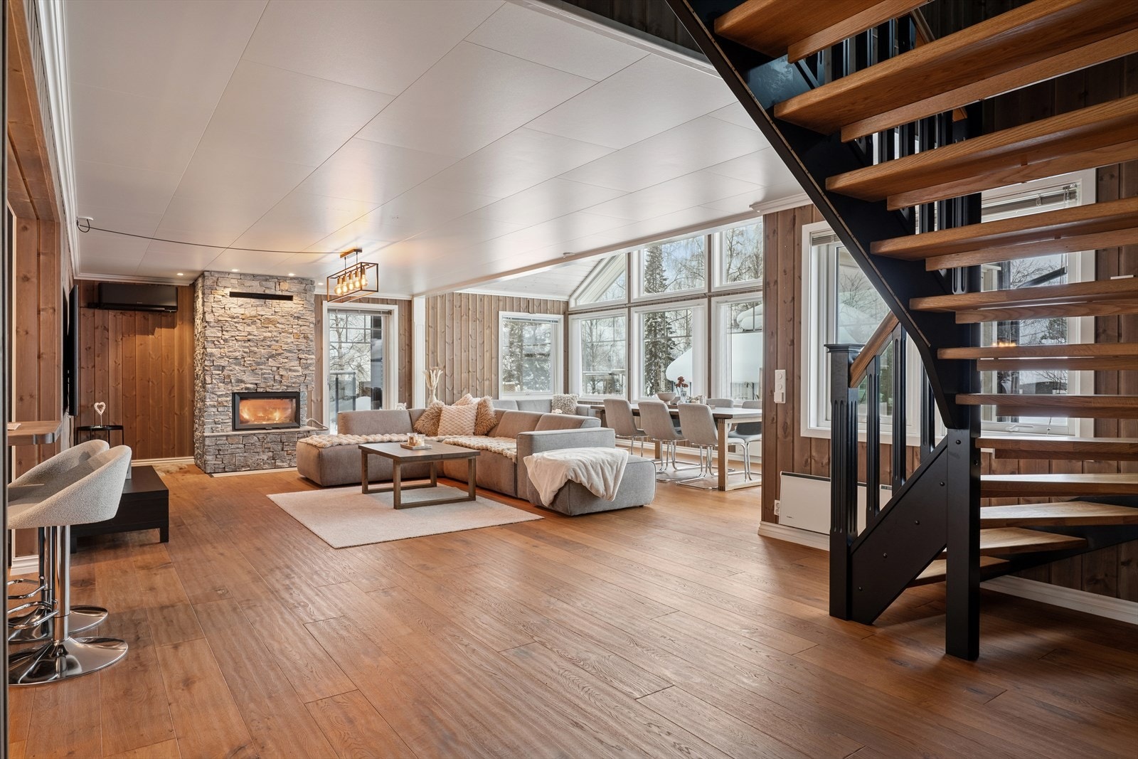 Stuen oppleves som et svært innbydende oppholdsrom med elegant parkett på gulvet og trepanel på vegger. Galleribilde