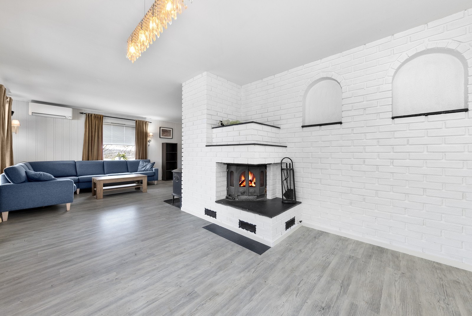 I rommet er det både en innmurt peisinnsats, vedovn og en varmepumpe som sikrer god varme på kalde dager. Galleribilde