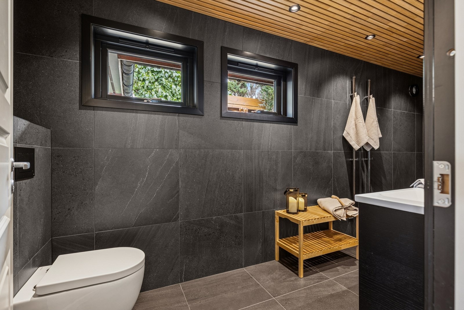 Rommet fremstår som en romslig velværeavdeling som byr på 2 heldekkende servanter, veggmontert toalett og dusjvegger/hjørne. Elektrisk styrt vifte. Galleribilde