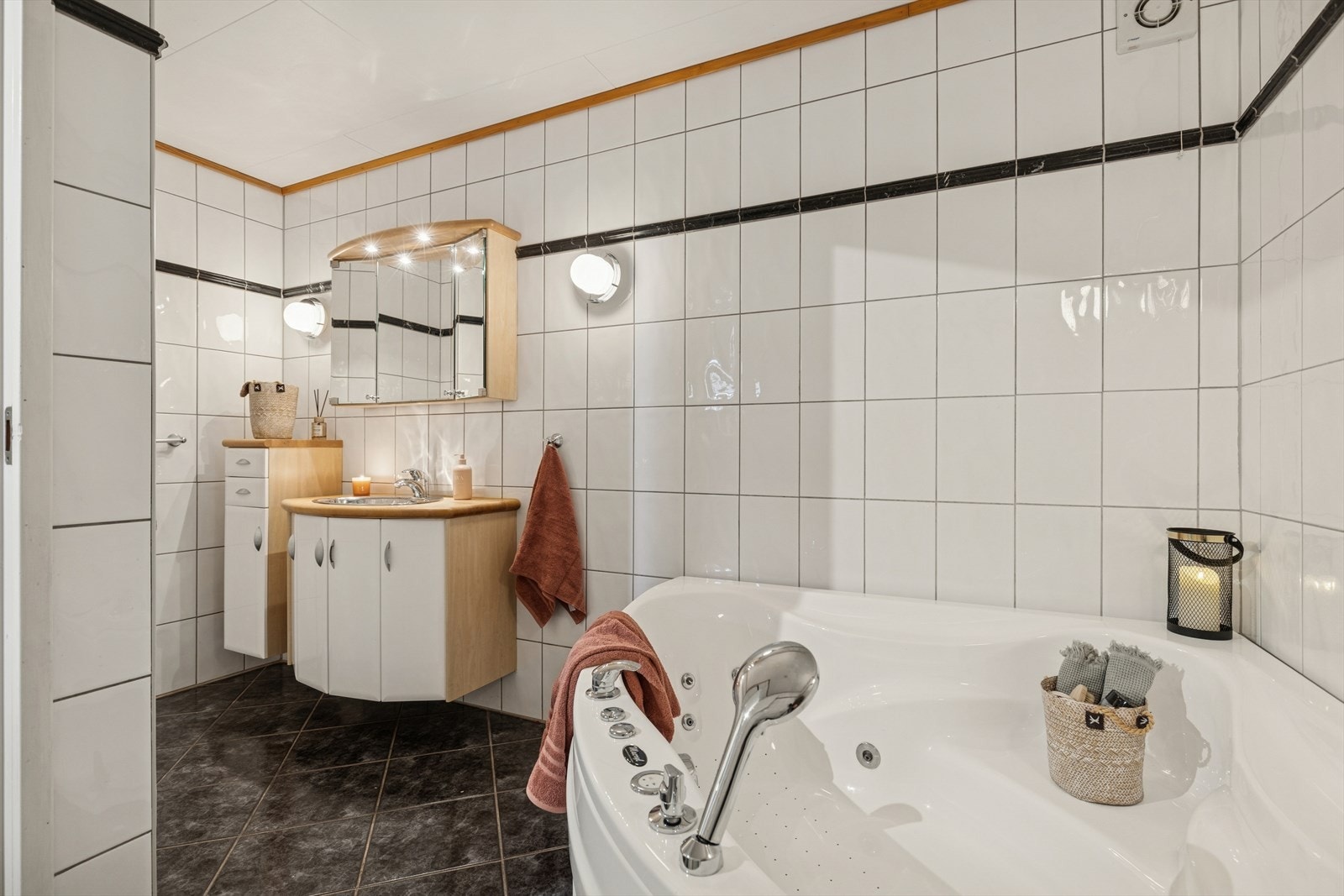 Lekkert helfliset bad med varme i gulv. Rommet har innredning med nedfelt servant, toalett og badekar. Elektrisk styrt vifte. Galleribilde