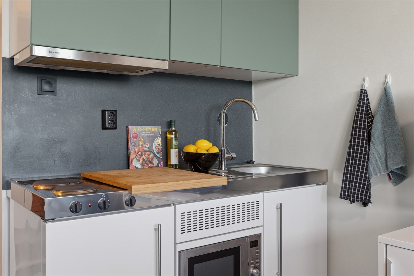 Plassbesparende og praktisk kjøkken fra 2021 med kjøleskap, koketopp og mikrobølgeovn. Galleribilde