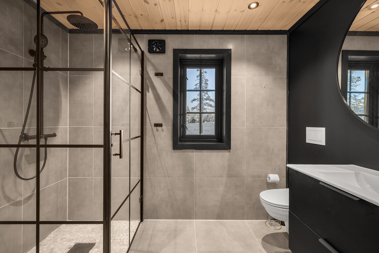 Delikat bad med romslig, innglasset dusjsone, veggmontert toalett og nedfelt servant Galleribilde