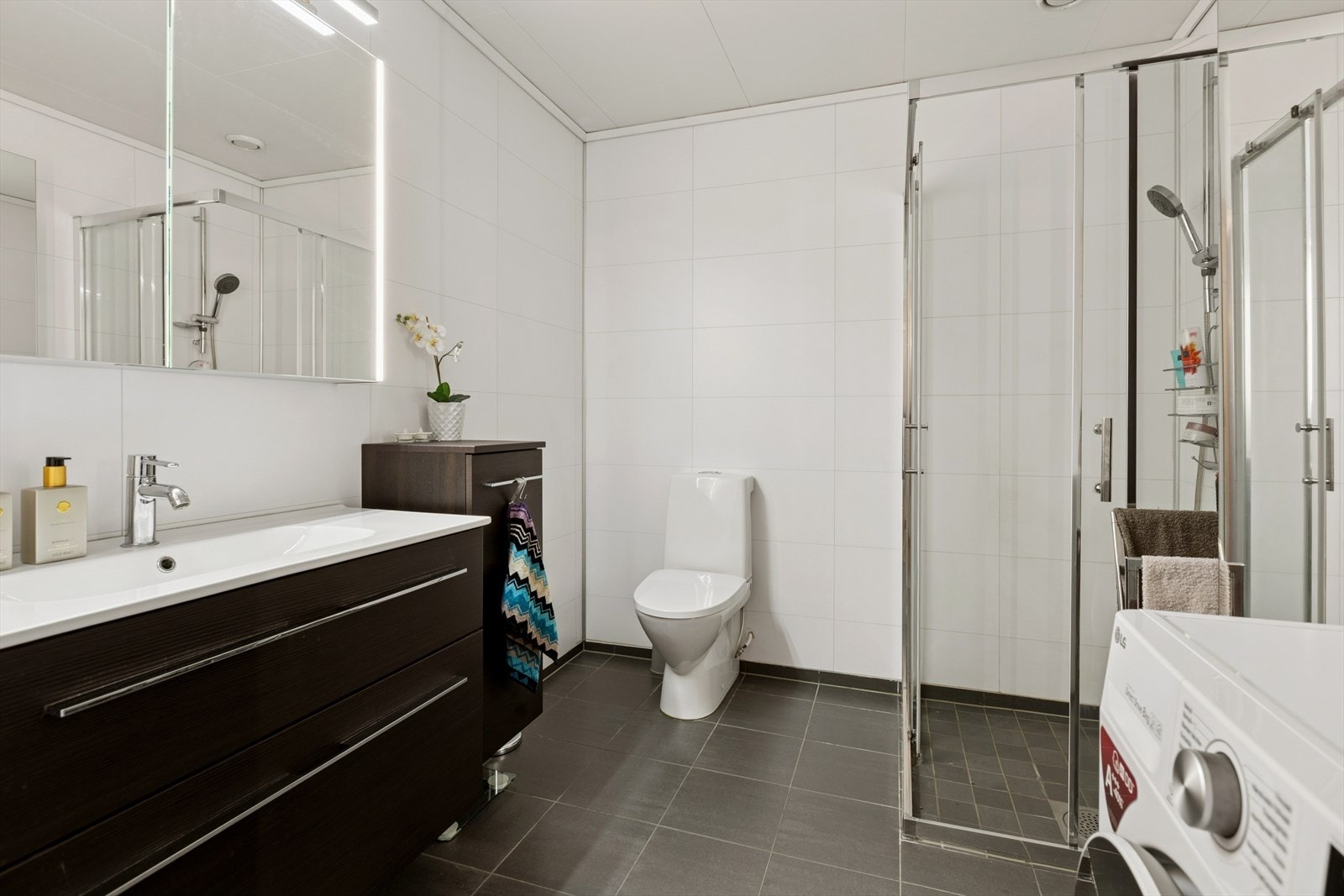 Badet har flislagt gulv med gulvvarme, og veggene er kledd med baderomsplater med flismønster, renovert i 2015. Galleribilde