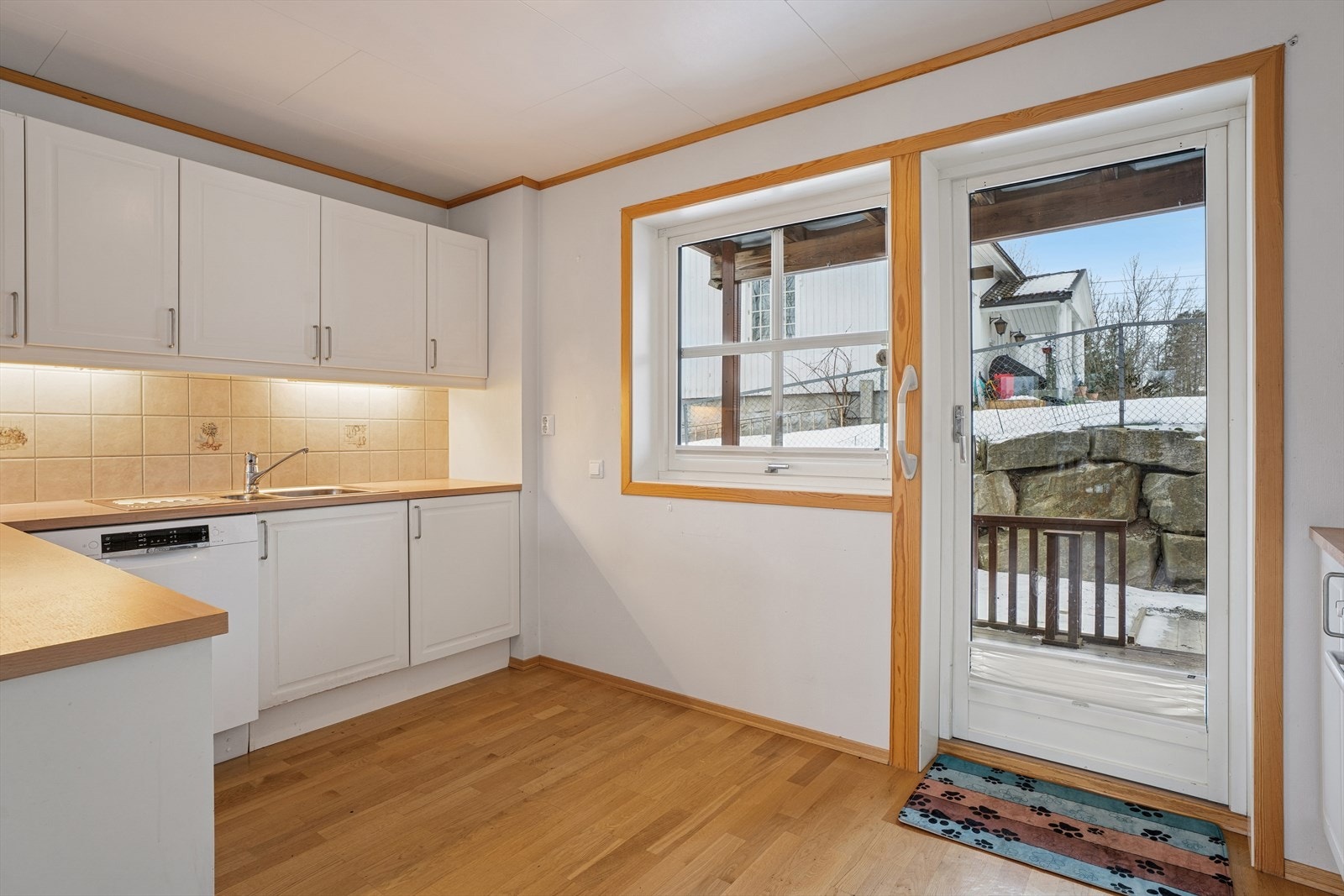 Kjøkkeninnredning med profilerte fronter, laminat benkeplate, nedfelt vask i rustfritt stål, kjøkkenarmatur og opplegg for oppvaskmaskin. Galleribilde