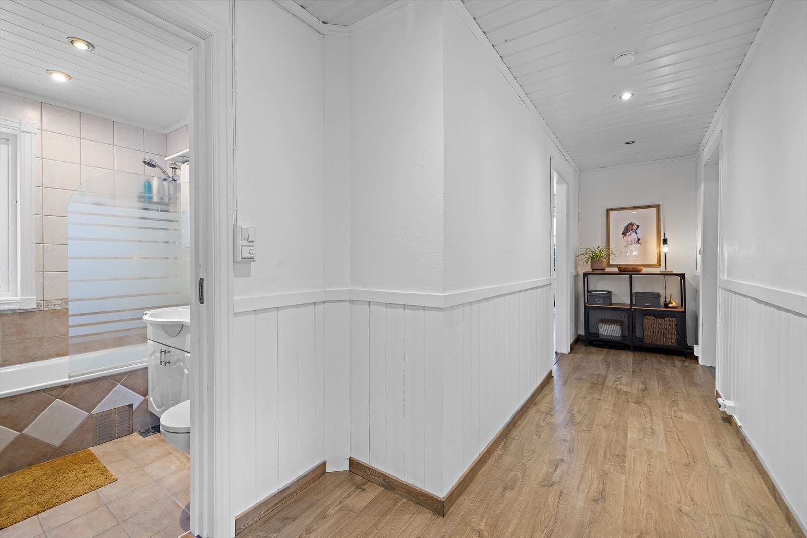 Gangen i første etasje har laminatgulv og fører videre til bad og 2 soverom. Galleribilde