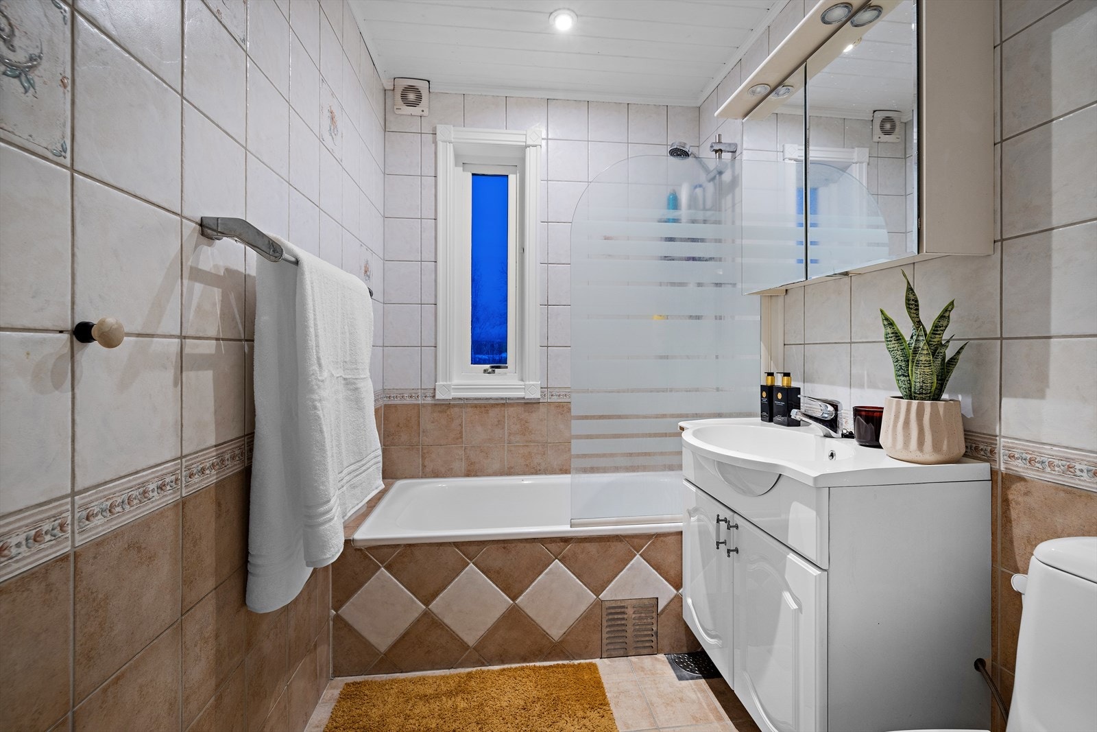 Badet fra 2006 har flislagt gulv med elektriske varmekabler, badekar og dusjvegg. Galleribilde