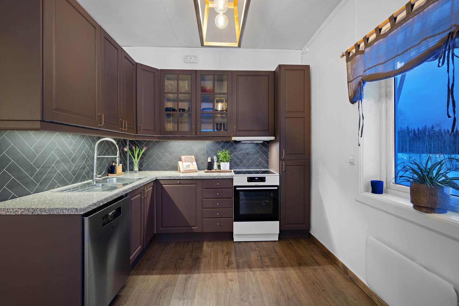 Rommet er utstyrt med frittstående hvitevarer og kjøkkenventilator med avtrekk ut. Galleribilde