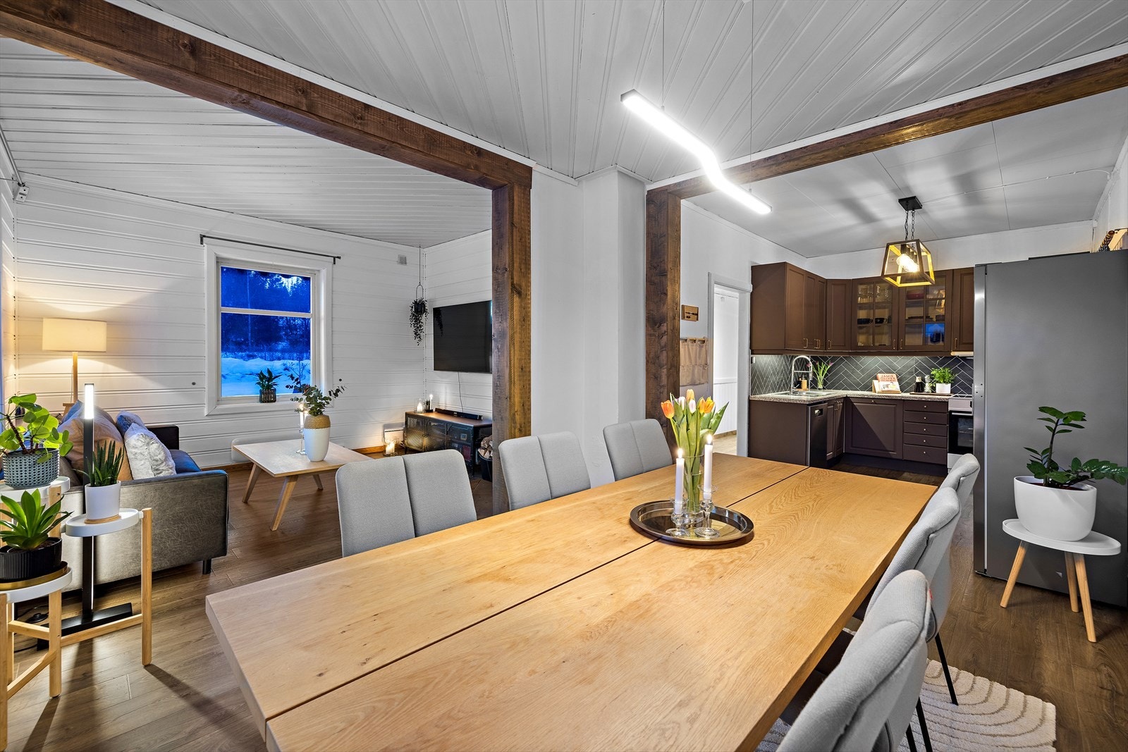 En åpen løsning mellom stue og kjøkken skaper en sosial og luftig atmosfære. Galleribilde