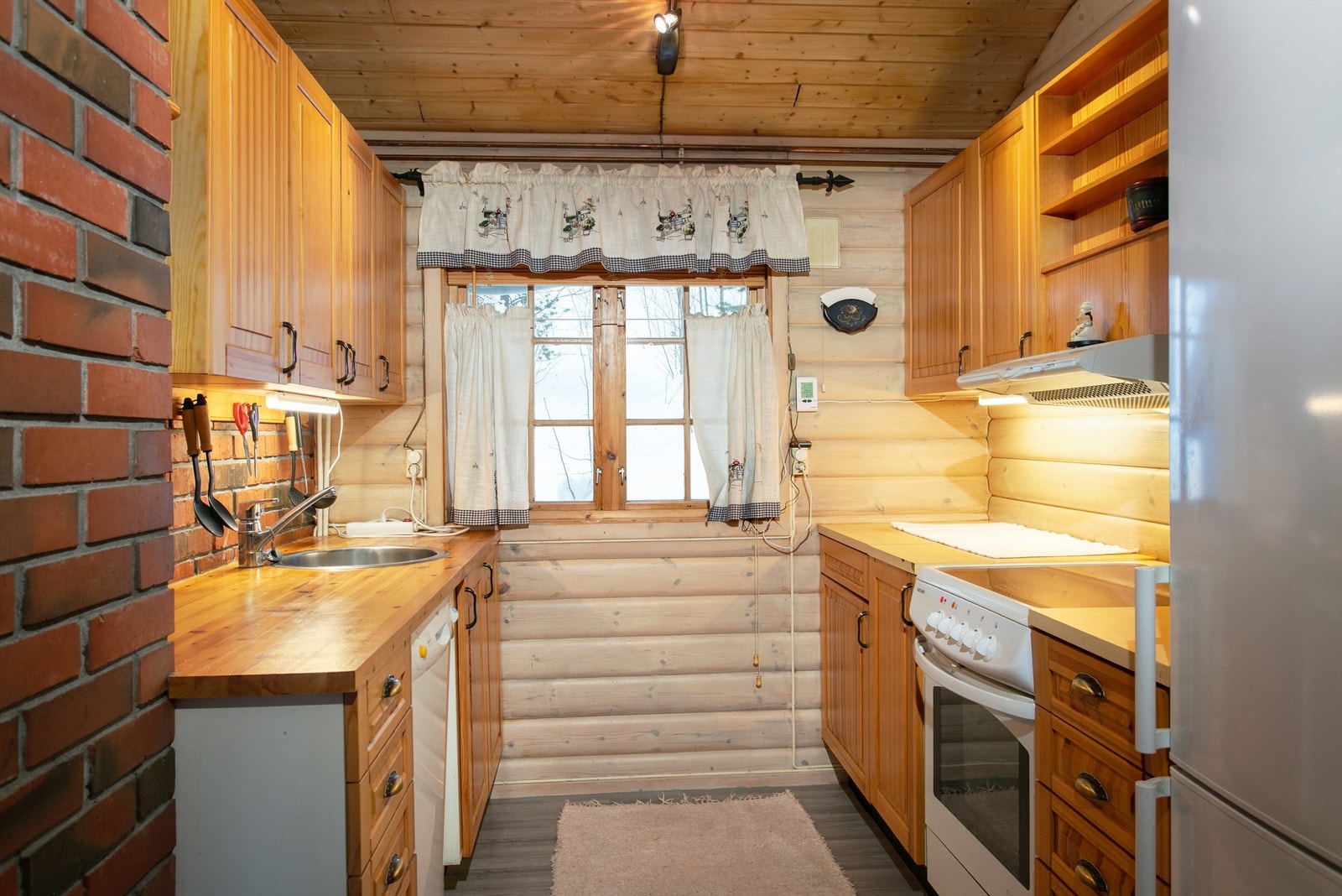 Kjøkkeninnredning i tre med profilerte fronter. Benkeplate av heltre og laminat. Galleribilde