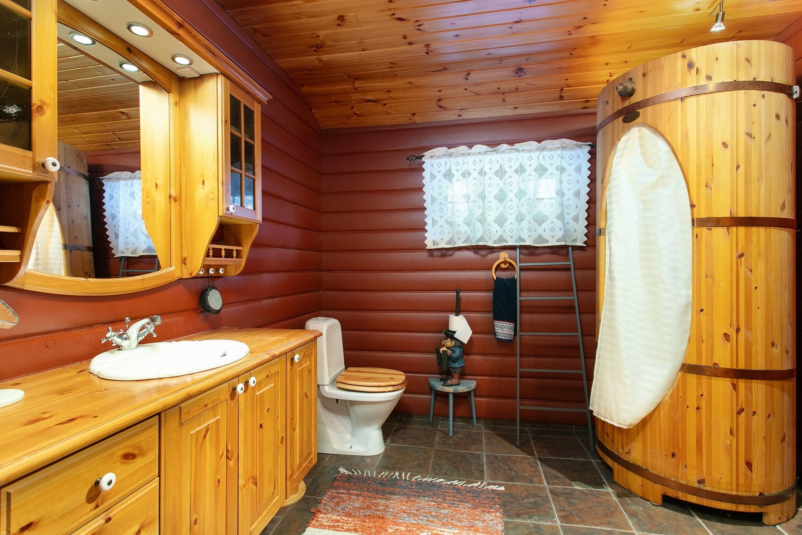 Romslig bad. Innredning, gulvstående toalett. Tønnedusjkabinett i tre. Galleribilde