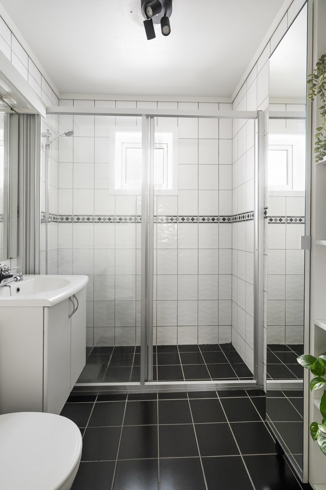 Lyst, flislagt bad med standard fra 2009. Badet har varmekabler, gulvmontert toalett og dusjnisje, samt vegghengt servantskap, speil og overlys. Galleribilde