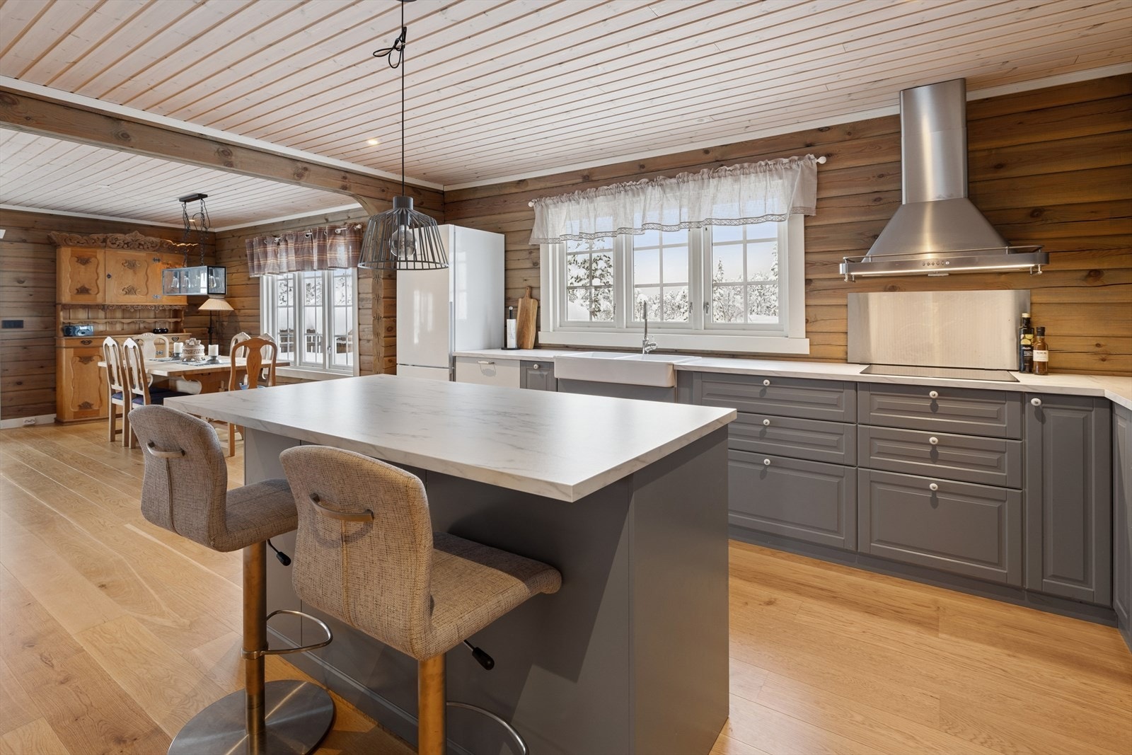 Videre kommer vi til kjøkkenet som er innredet med profilerte fronter og en praktisk kjøkkenøy. Benkeplaten er i laminat. Galleribilde