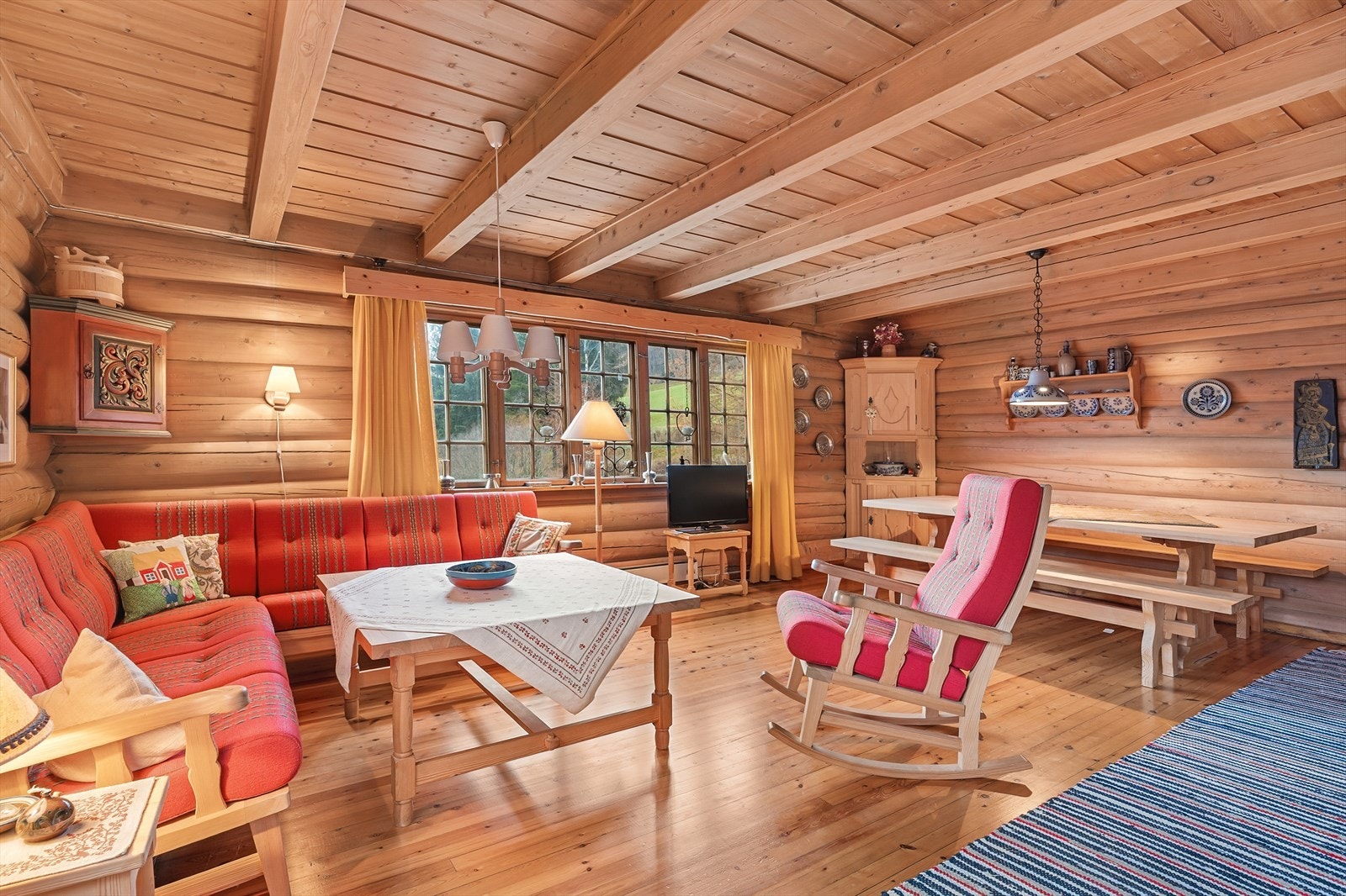 Den romslige stuen i hovedetasjen har solide tømmervegger og plass til flere sittegrupper. Galleribilde